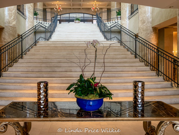 A photo of the majestic staircase that leads from the lower level up to the hotel entrance lobby.
