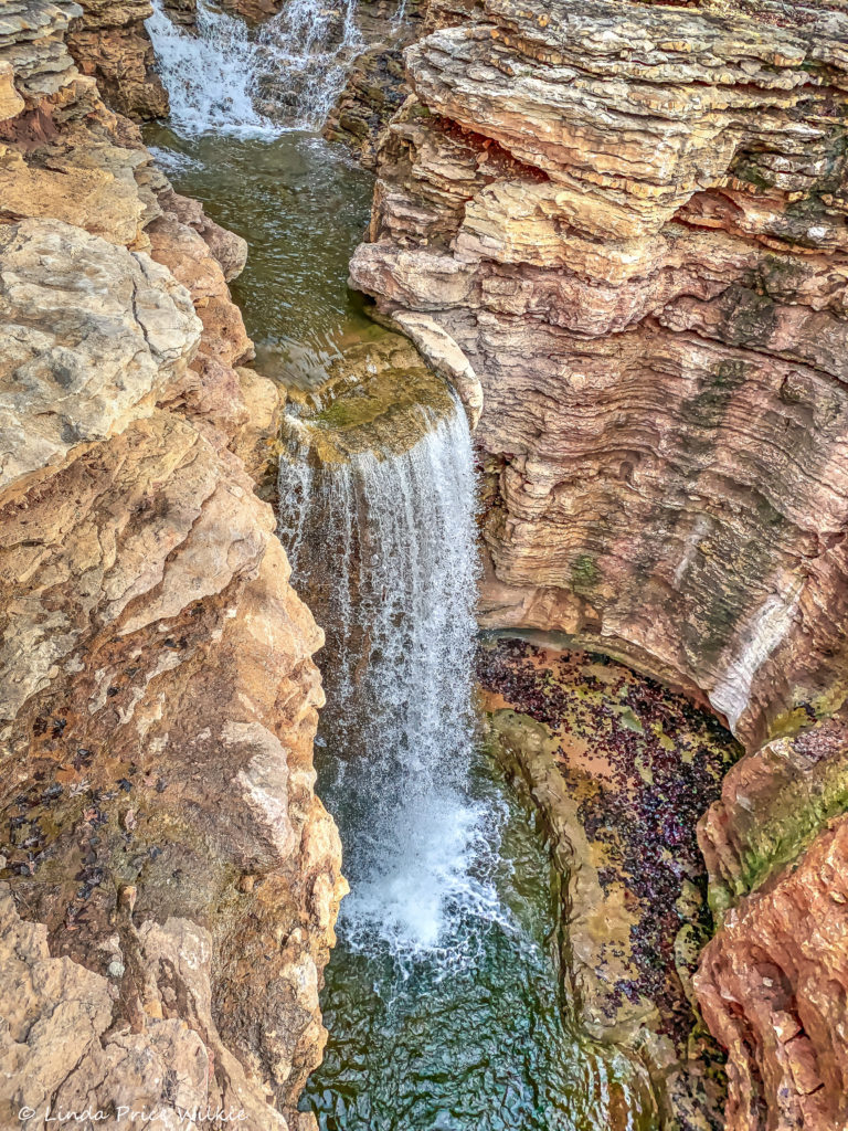 A photo of a waterfall flowing down table rocks into natural pools several stories below.